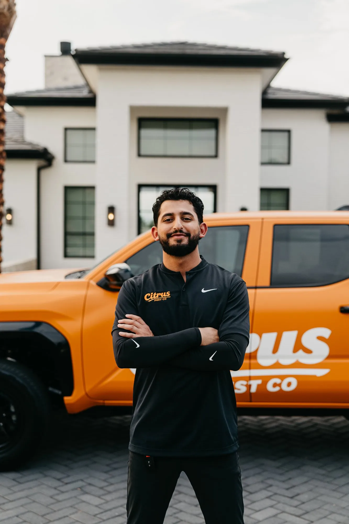 Citrus Pest Co owner standing in front of the branded orange truck